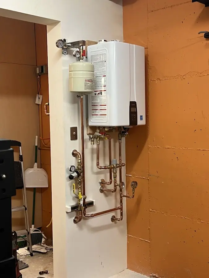 Plumbing technician inspecting water heater connections in San Luis Obispo